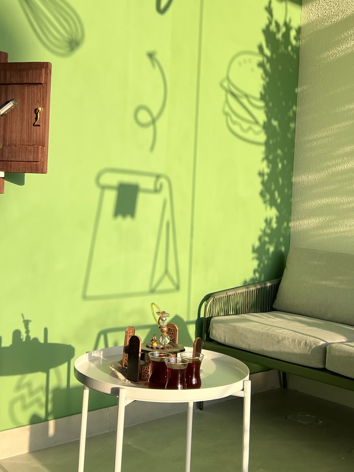 Green interior seating area with cafeteria mural and tea service